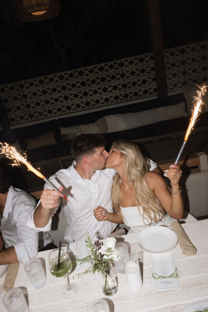 Couple kissing with sparklers at engagement party